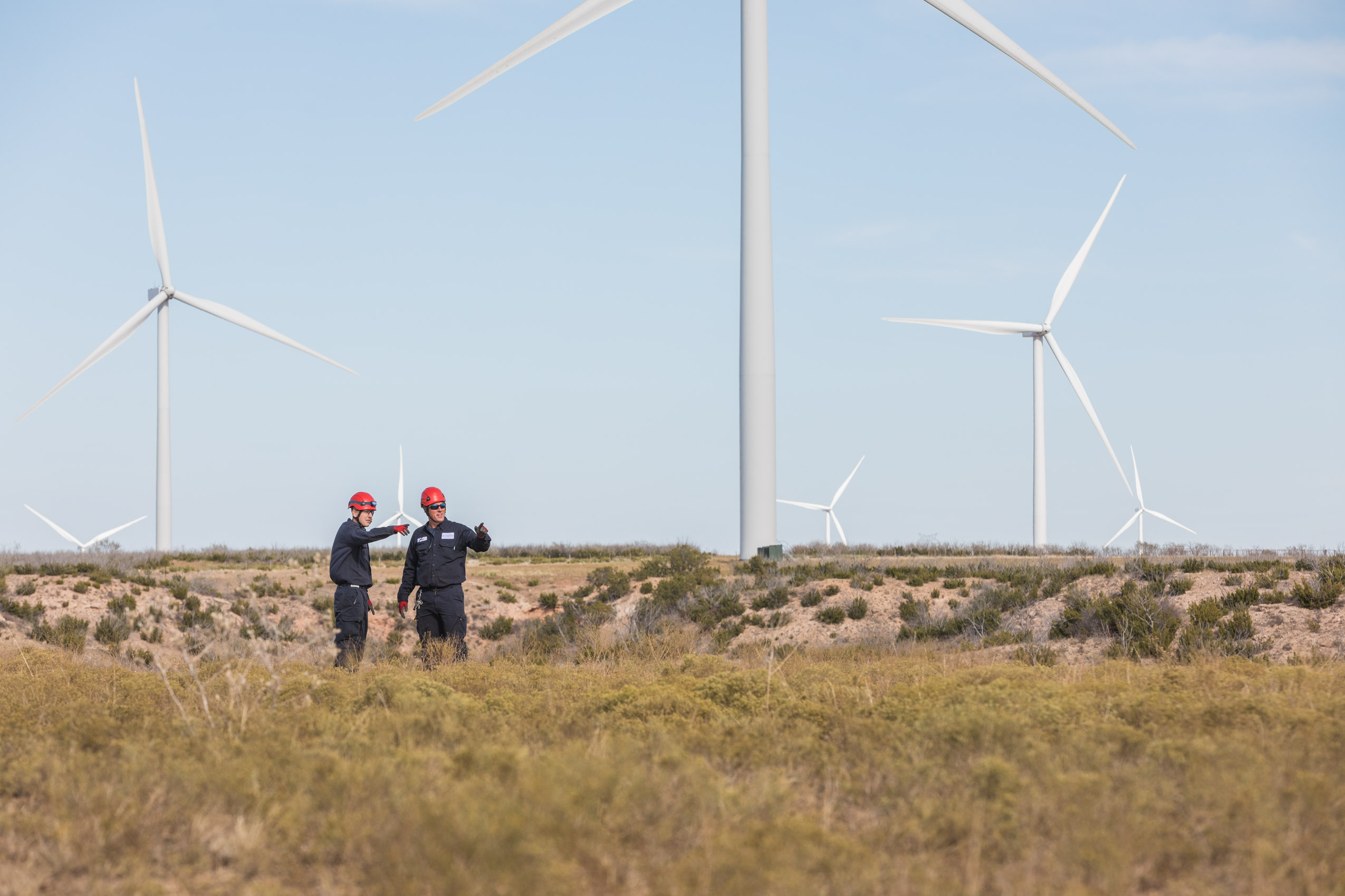 Wind turbine technicians on clean renewable energy wind farm.