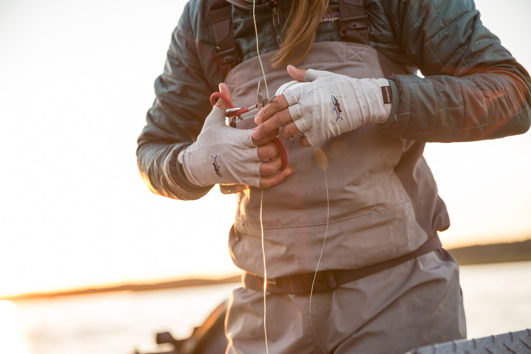 Kate Taylor, prepping her rod in Alaska fishing for salmon by outdoor photographer Rich Crowder